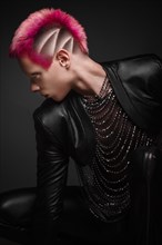 Young man with pink hair and creative makeup in art clothes. Photo taken in the studio