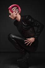 Young man with pink hair and creative makeup in art clothes. Photo taken in the studio