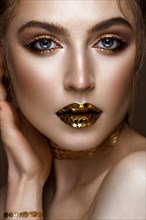Beautiful girl with a golden shiny make-up and stars on her lips. Beauty face. Photo taken in the studio