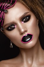 A beautiful girl with a black creative make-up and a pink thread on her lips. Beauty face. Photos shot in studio