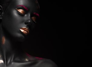 Fashion portrait of a dark-skinned girl with color make-up.Beauty face. Picture taken in the studio on a black background