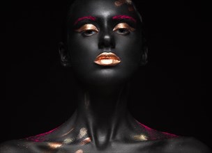 Fashion portrait of a dark-skinned girl with color make-up.Beauty face. Picture taken in the studio on a black background