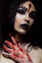 Demon girl with a bullet in the head and her throat cut. An image for Halloween. Photos shot in studio