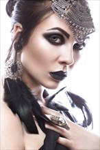 Beautiful girl in style of black queen. Image for a Halloween. Photos shot in the studio on a white background