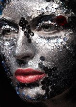 Girl with glitter and rhinestones on her face. Beauty close-up. Picture taken in the studio