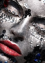 Girl with glitter and rhinestones on her face. Beauty close-up. Picture taken in the studio
