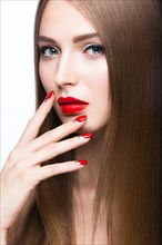 Beautiful young girl with a bright make-up and red nails. Picture taken in the studio on a white background
