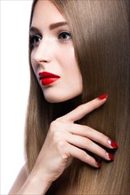 Beautiful young girl with a bright make-up and red nails. Picture taken in the studio on a white background