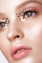 Beautiful girl with creative bright makeup with rhinestones Beauty face. Photos shot in studio