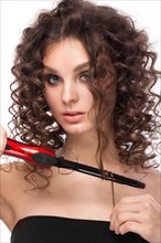 Beautiful brunette girl with a perfectly curly hair with curling