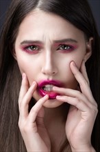 Girl with pink lipstick smeared across his face. Creative makeup. Picture taken in the studio