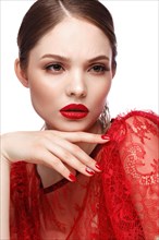 Beautiful girl in red dress with classic make-up and red manicure. Beauty face. Photo taken in the studio