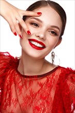Beautiful girl in red dress with classic make-up and red manicure. Beauty face. Photo taken in the studio
