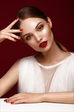 Beautiful girl in white dress with classic make-up and red manicure. Beauty face. Photo taken in the studio