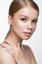 Beautiful young girl with a light natural make-up and French manicure. Beauty face. Picture taken in the studio on a white background