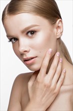 Beautiful young girl with a light natural make-up and French manicure. Beauty face. Picture taken in the studio on a white background