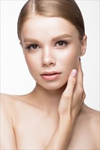 Beautiful young girl with a light natural make-up and French manicure. Beauty face. Picture taken in the studio on a white background