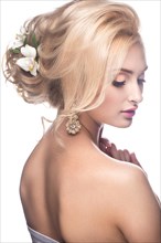 Beautiful blond girl in the image of a bride with flowers in her hair. Picture taken in the studio on a white background. Beauty face. Wedding image