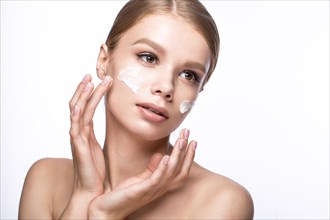 Beautiful young girl with cream on the skin and French manicure. Beauty face. Picture taken in the studio on a white background