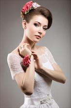 Portrait of a beautiful woman in the image of the bride with flowers in her hair. Picture taken in the studio on a black background