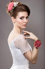 Portrait of a beautiful woman in the image of the bride with flowers in her hair. Picture taken in the studio on a black background