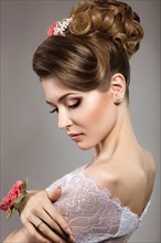 Portrait of a beautiful woman in the image of the bride with flowers in her hair. Picture taken in the studio on a black background