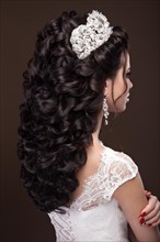 Beautiful brunette girl in the image of the Arab bride in a wedding dress and a crown on her head. Beauty face. Picture taken in the studio