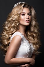 Beautiful blonde bride in wedding image with curls and crown. Beauty face. Picture taken in the studio