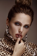 Beautiful sexy woman in a leopard coat and earrings