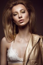 Beautiful girl in a gold dress with creative makeup and hair. The beauty of the face. Photos shot in the studio