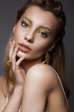 Beautiful girl in Underwear with creative gold makeup and hair. The beauty of the face. Photos shot in the studio