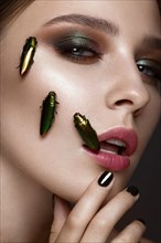 Portrait of beautiful girl with colorful make-up and cockroaches. Beauty face. Photo taken in the studio