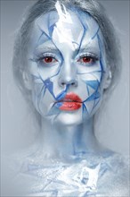 Beautiful girl in an unusual winter look with red lips. Creative make up. Art look. Photo taken in studio