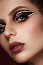 Portrait of a beautiful woman in a disco style image with creative makeup and hairstyle
