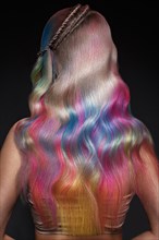 Beautiful girl with multi-colored hair and creative make-up and hairstyle. Beauty face. Photo taken in the studio
