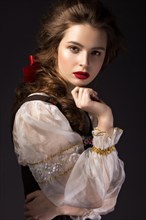 Beautiful Russian girl in national dress with a braid hairstyle and red lips. Beauty face. Picture taken in the studio on a black background
