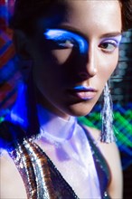 Fashion model beautiful girl in fashionable clothes in ultraviolet light