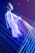 Fashion model beautiful girl in fashionable clothes in ultraviolet light