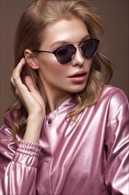 Beautiful girl in stylish pink clothes with sunglasses and sexy lips. Beauty face. Photo taken in the studio