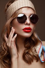 Beautiful girl in stylish clothes with sunglasses and red sexy lips. Beauty face. Photo taken in the studio