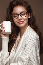 Beautiful girl in a cozy sweater with a cup of tea