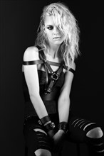 Daring girl model in black leather dress in the style of rock