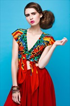 Beautiful fashionable woman an unusual hairstyle in bright clothes and colorful accessories. Cuban style. Picture taken in the studio on a bright background