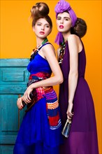 Beautiful fashionable women an unusual hairstyle in bright clothes and colorful accessories. Cuban style. Picture taken in the studio on a bright background