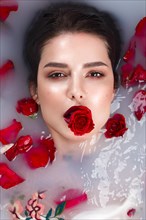 Beautiful girl with classic make-up and red lips in the bathroom with flowers. Beauty face. Photo taken in the studio