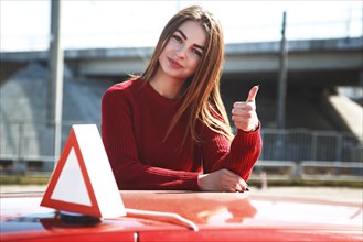 Young beautiful happy woman posing near training car