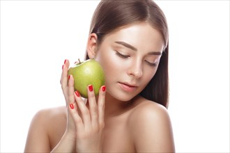Beautiful young girl with a light natural make-up and perfect skin with apple in her hand. Beauty face. Picture taken in the studio on a white background