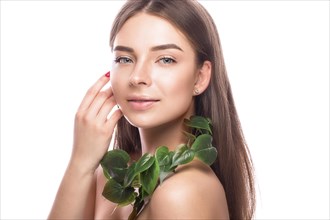 Beautiful young girl with a light natural make-up and perfect skin with Green branch in her hand. Beauty face. Picture taken in the studio on a white background