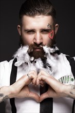 Funny bearded man with feathers and wings in the image of Cupid Valentine's Day. Portrait shot in studio
