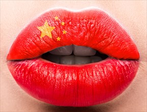 Female lips close up with a picture of the flag of China. Red color
